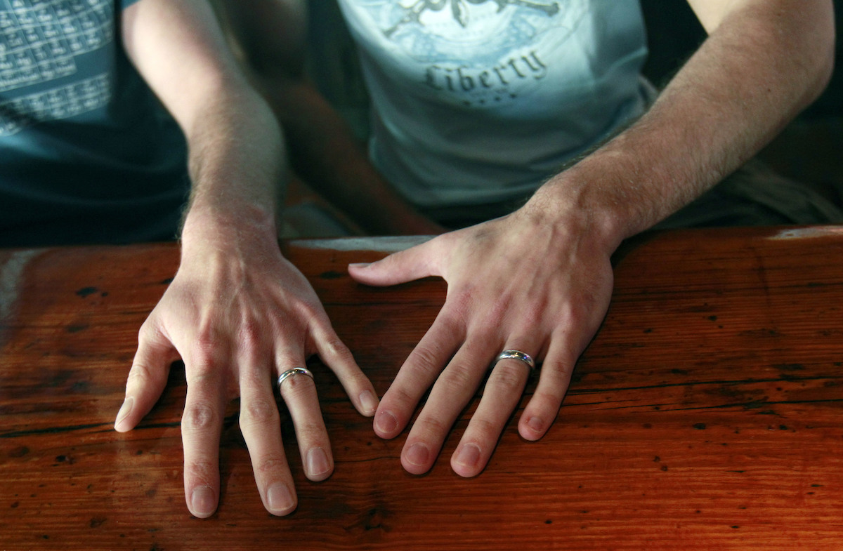 Two male hands with wedding rings gay marriage
