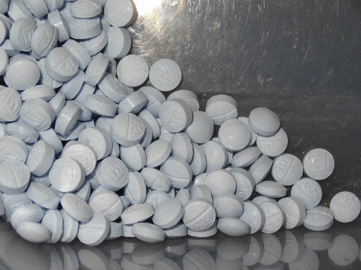 Fentanyl pills on a silver tray background