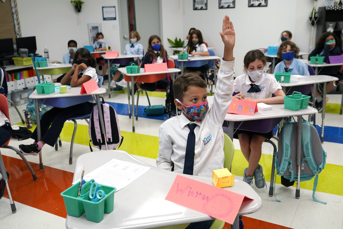 Picture of Miami-Dade Public School students raising hands wearing masks