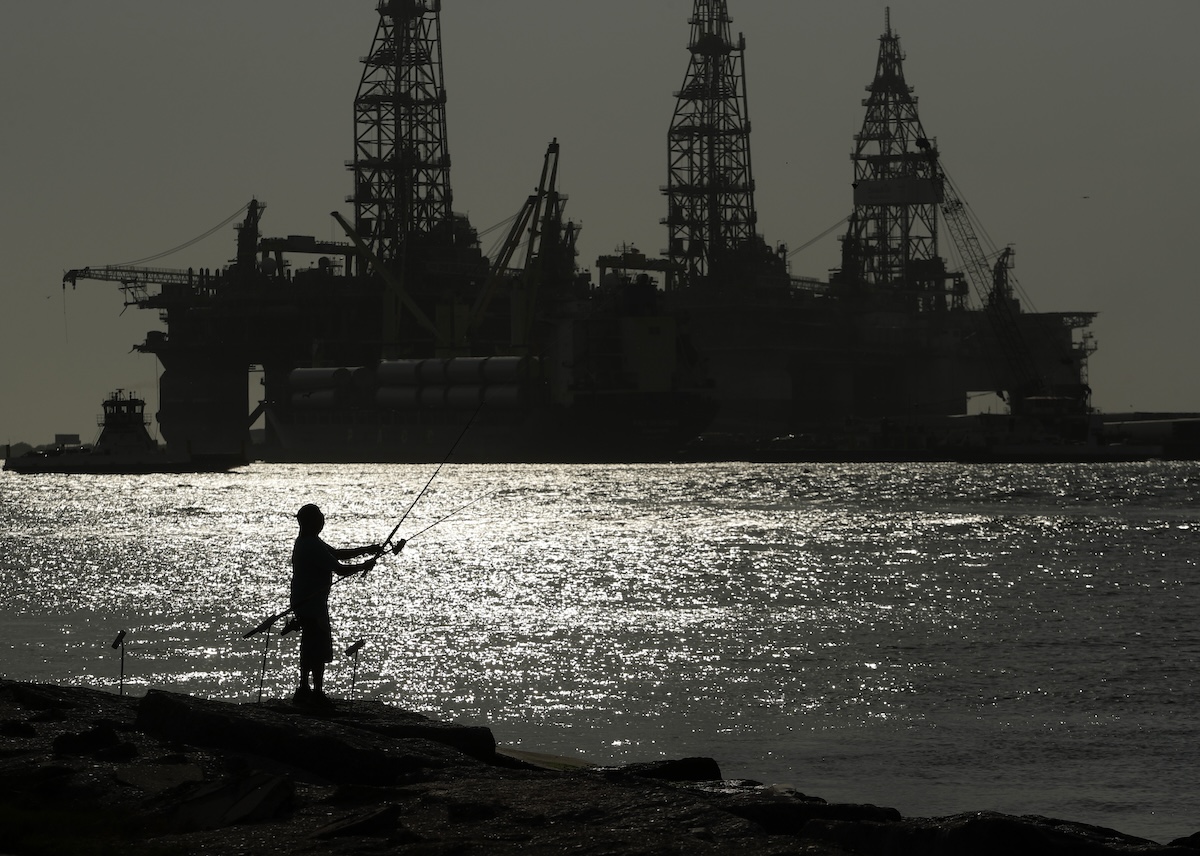 Man fishing near oil platforms in Port Aransas, Texas
