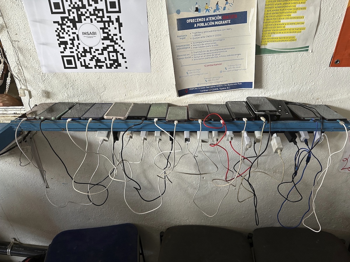 SPANISH: Migrant shelter phones on shelf charging