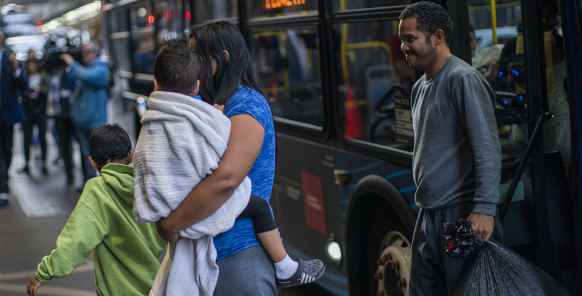 Asylum seekers get off a bus in NYC, 5-19-2023