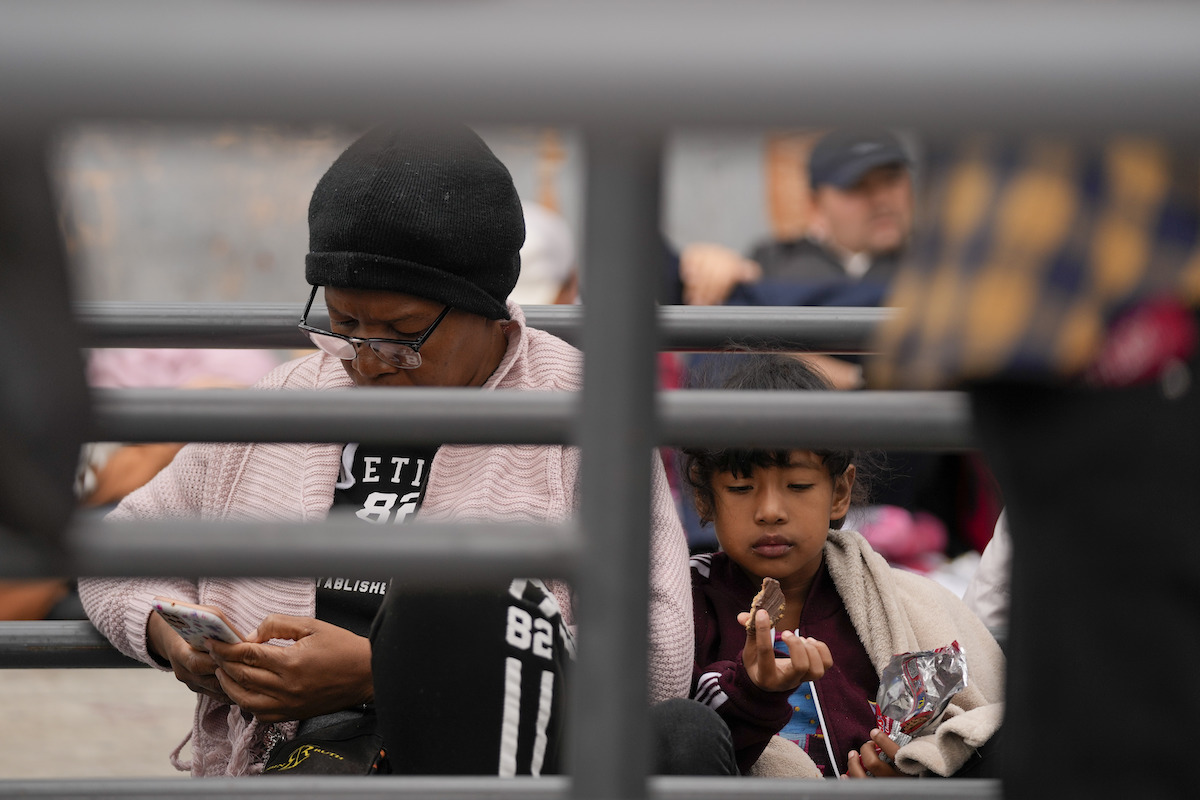 ENGLISH - Woman looking at her phone at the border