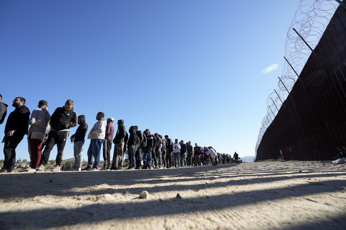 Migrants line up against the U.S.-Mexico border, 10-24-2023