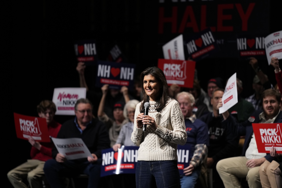 Nikki Haley at Exeter, N.H. rally surrounded by people holding signs, 1- 21-2024