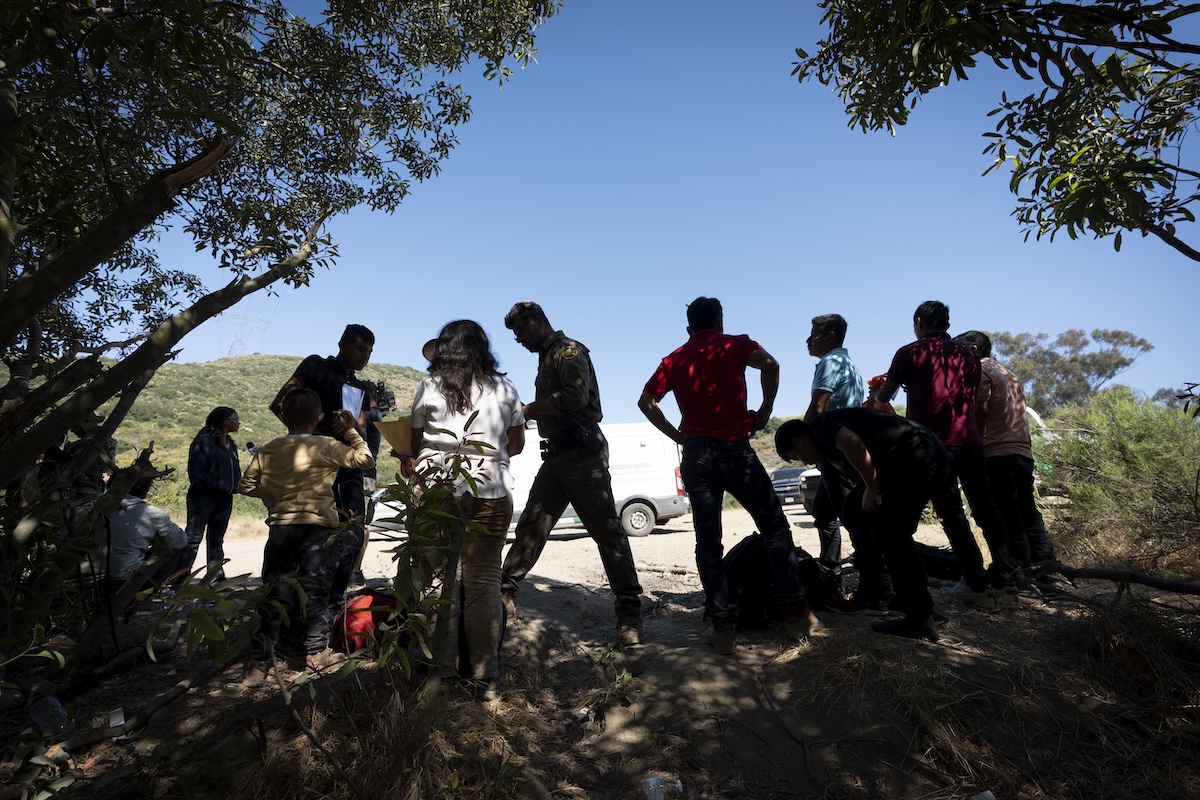 Silhouette migrants speaking to border patrol 06-05-2024