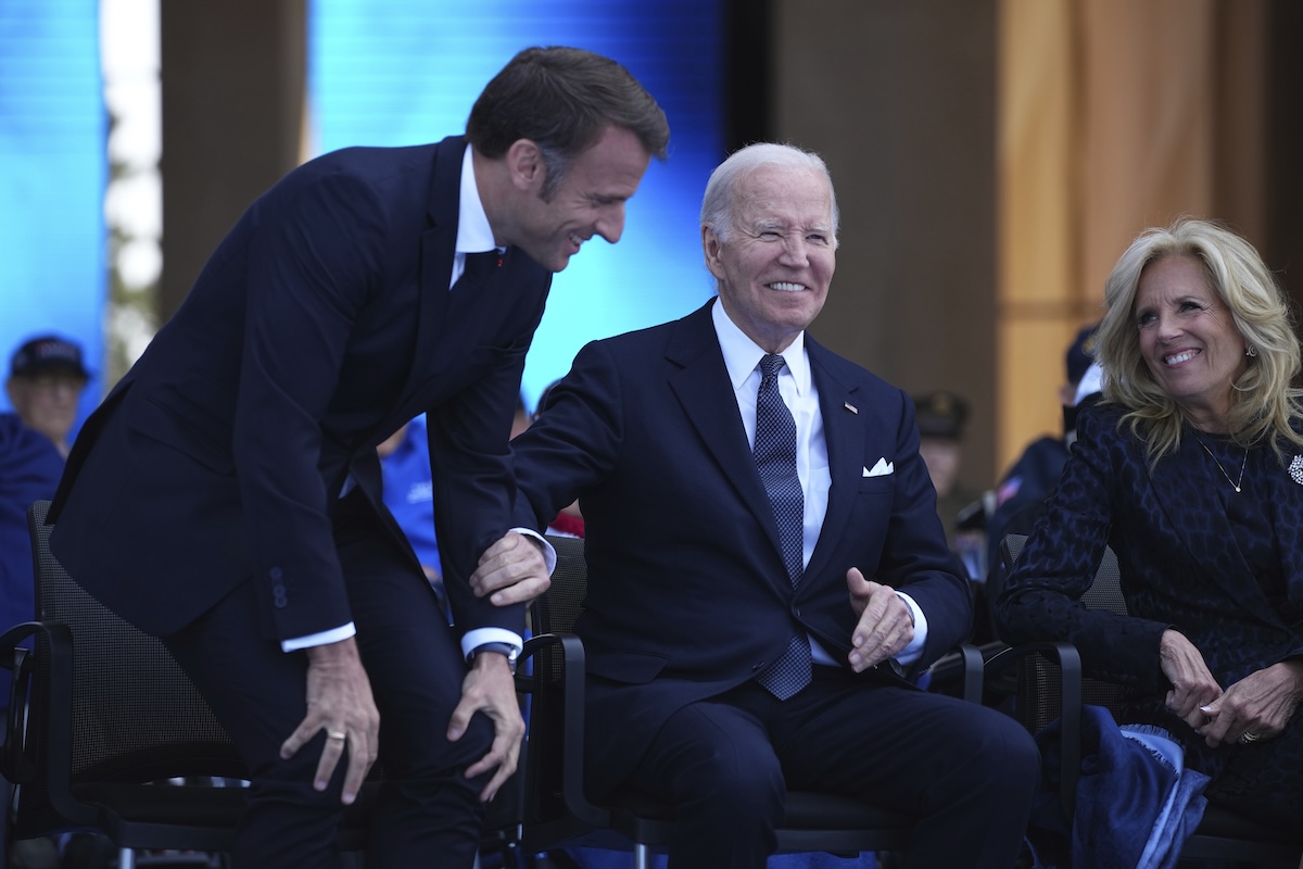 Joe Biden (seated) and Emmanuel Macron at US cemetery in Colleville-sur-Mer, Normandy 06-06-2024