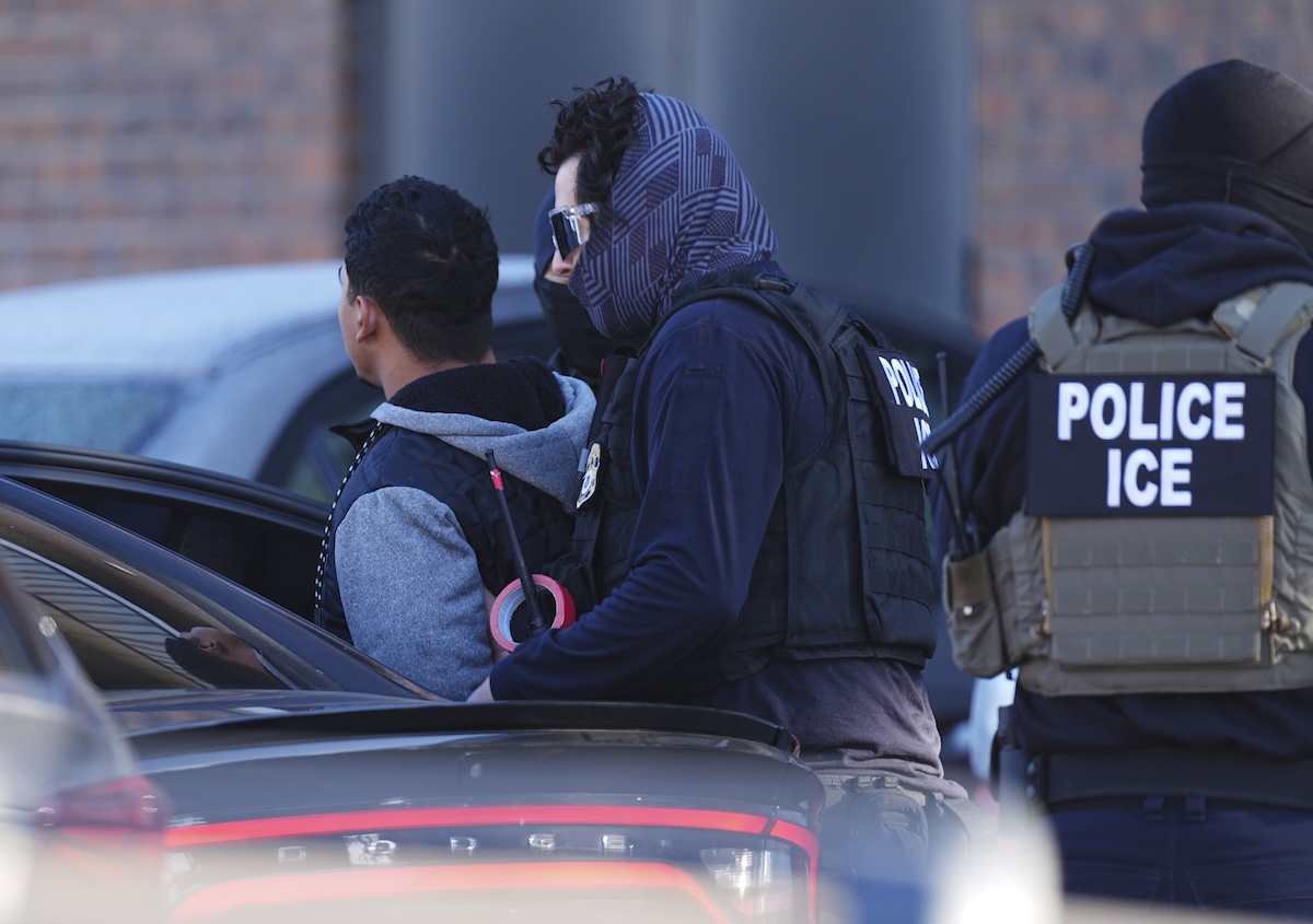 ICE officer loading a migrant into a car 02-05-2025