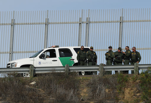 border patrol agents near a fence
