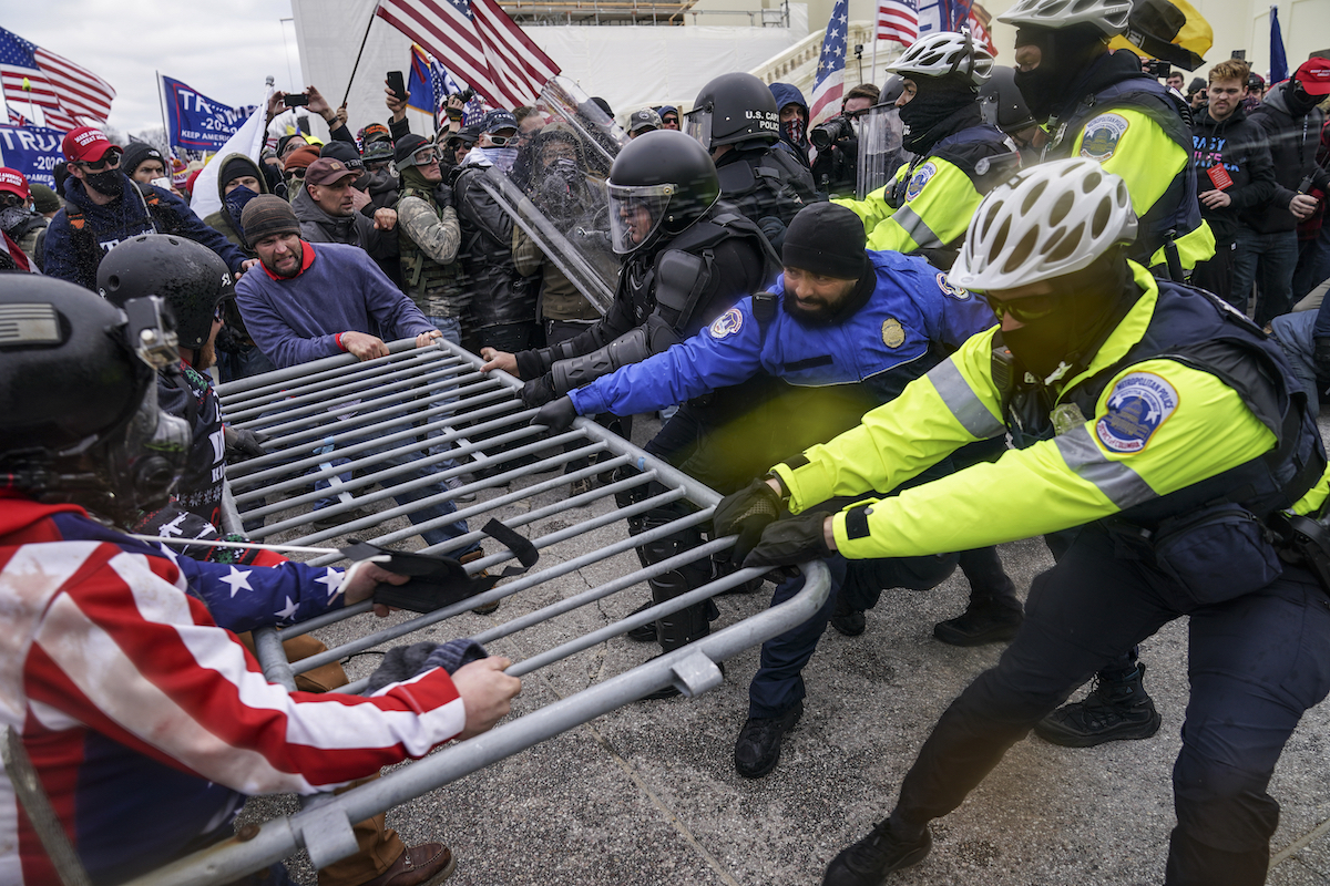 Jan. 6 rioters pull police barricade