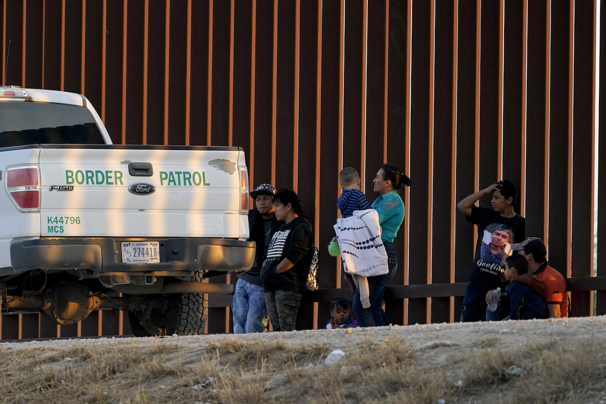 Migrants next to CBP truck March 2021