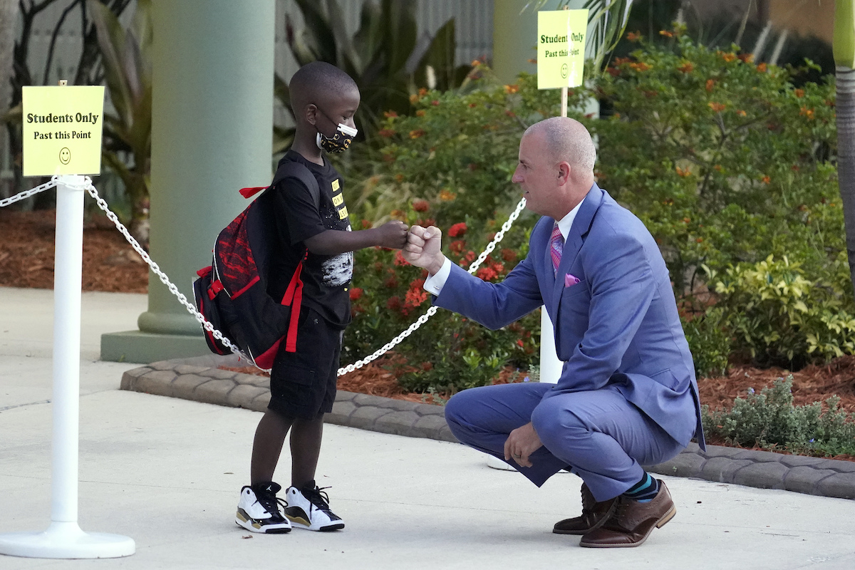 Kids at school COVID-19 masks fist bumping