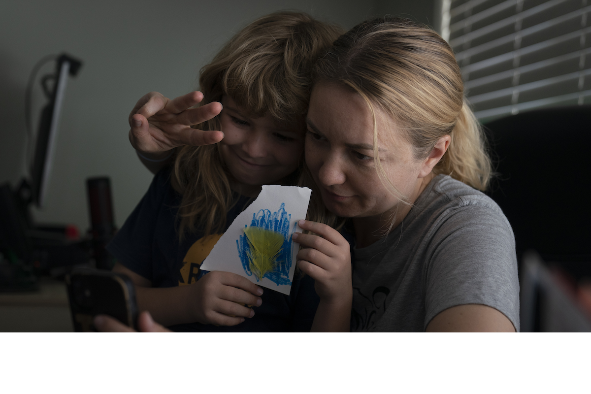 Ukrainian immigrant in CA holding a picture her son made of the flag