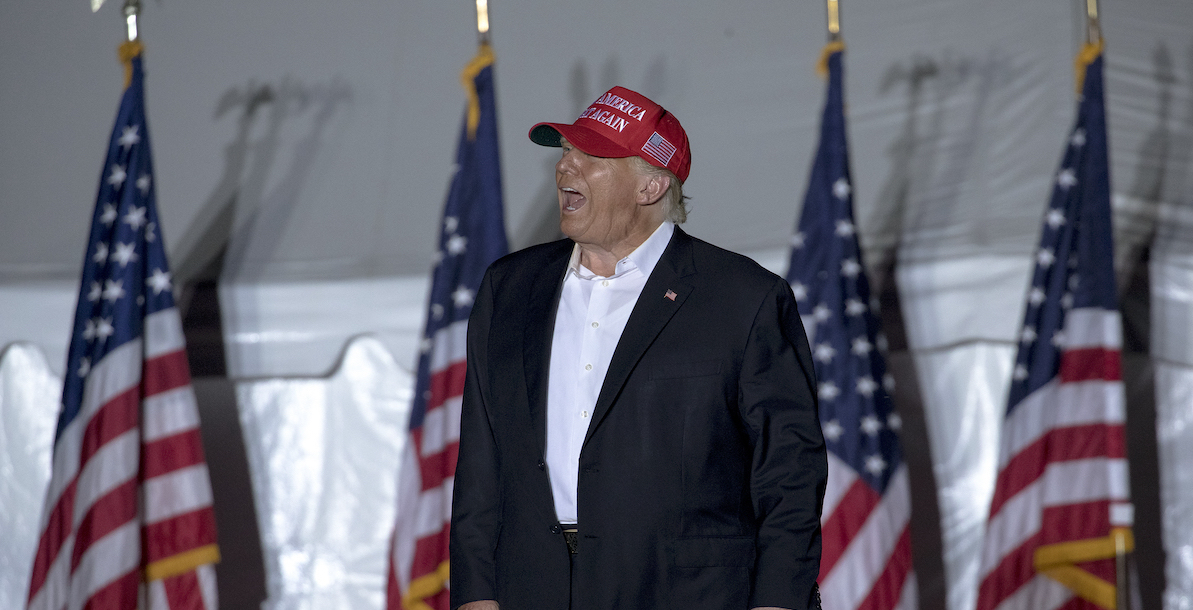 Donald Trump at rally holding MAGA hats in TX Oct 2022