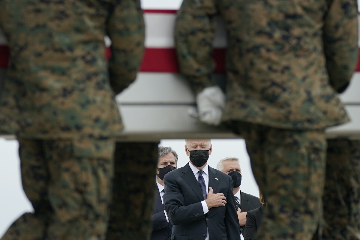 President Joe Biden holds his hand to his heart as a carry team transfers the remains of Marine Corps Lance Cpl. Kareem M. Nikoui, 20, at Dover Air Force Base. Nikoui was one of 13 U.S. service members who were killed in Afghanistan. (AP Photo)