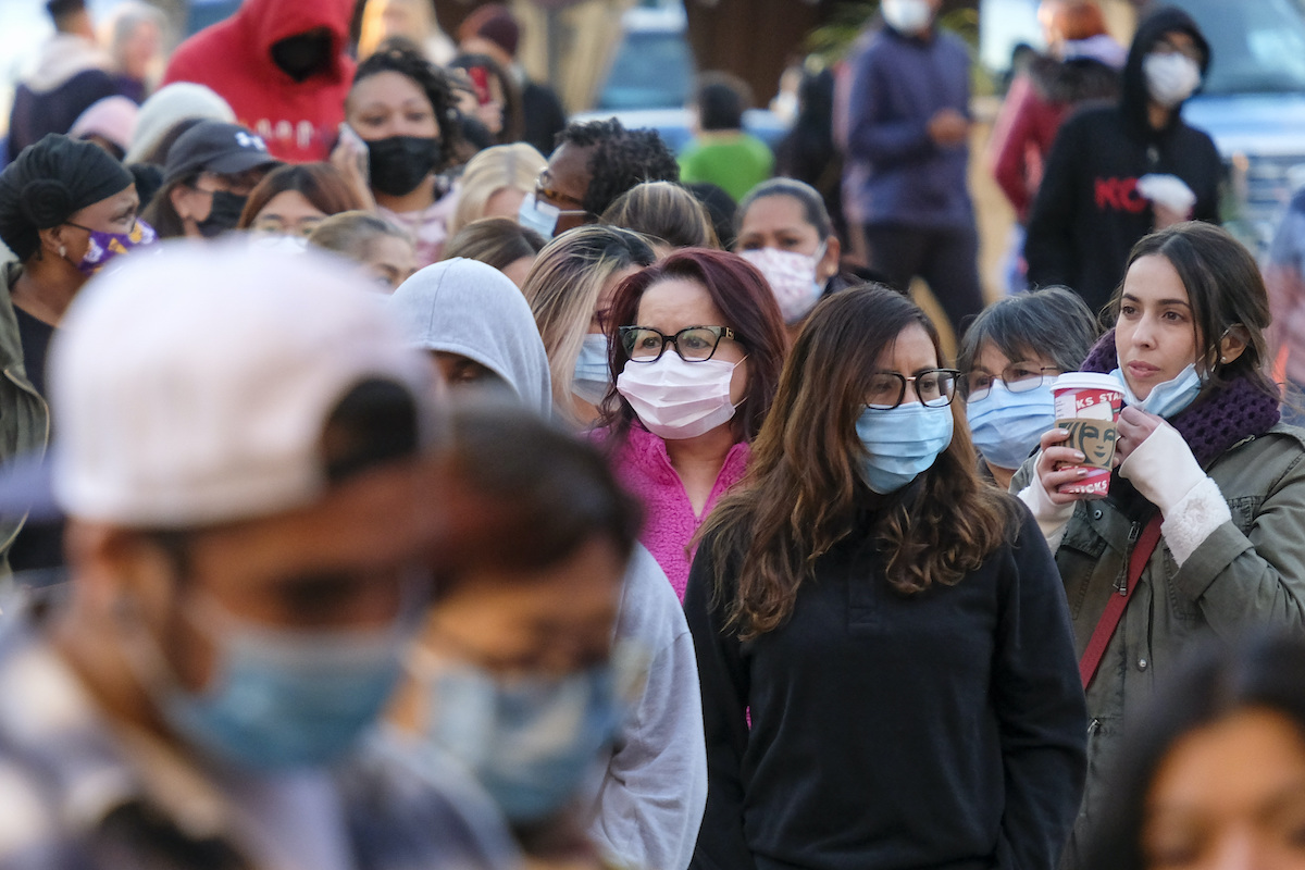 Black Friday shoppers wearing face masks wait to enter a store in Commerce, Calif., Nov. 26, 2021 (AP).