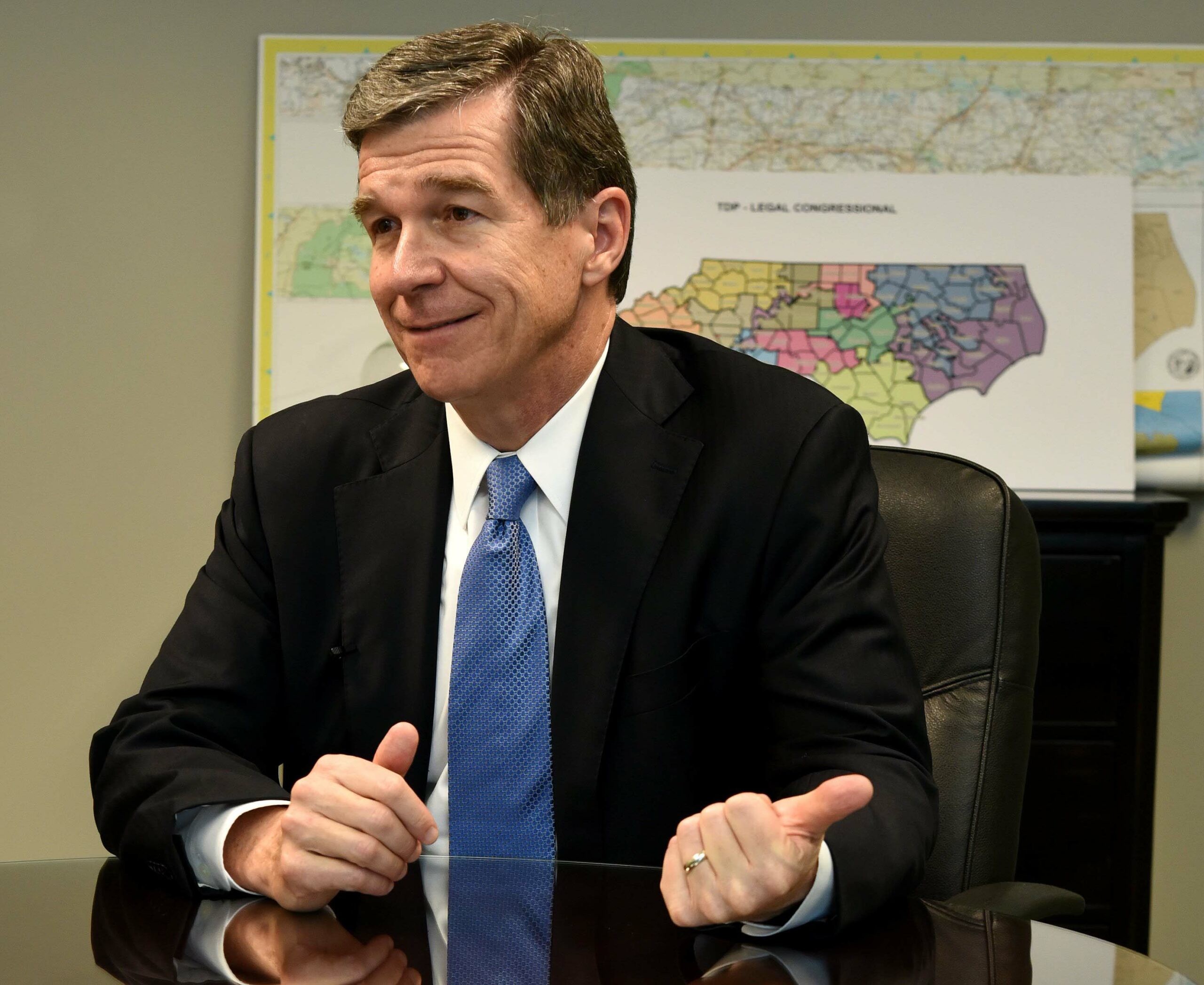 Roy Cooper seated with map