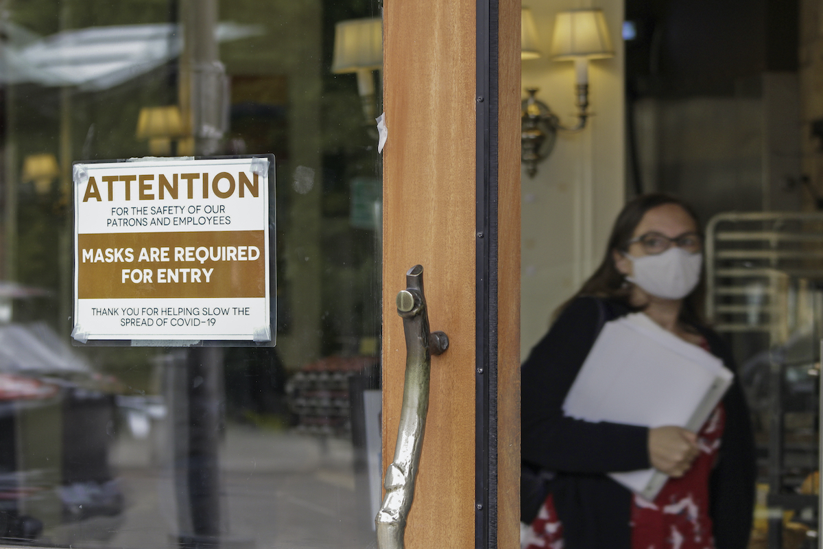A May 21, 2021 file photo shows a sign reminding customers to wear their masks inside a Lake Oswego, Oregon bakery.