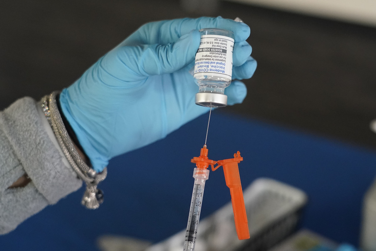 Nurse loads a syringe with Moderna vaccine booster Nov. 18, 2022