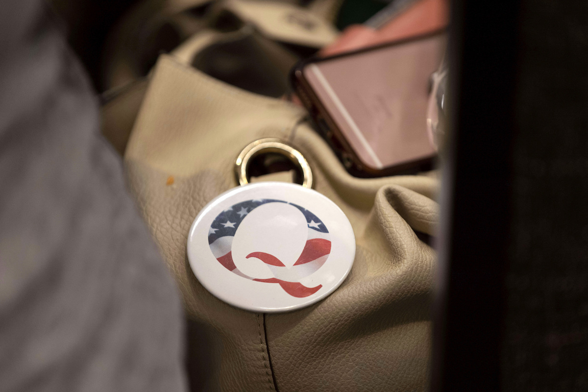 QAnon button on a bag at an August election integrity event 2022