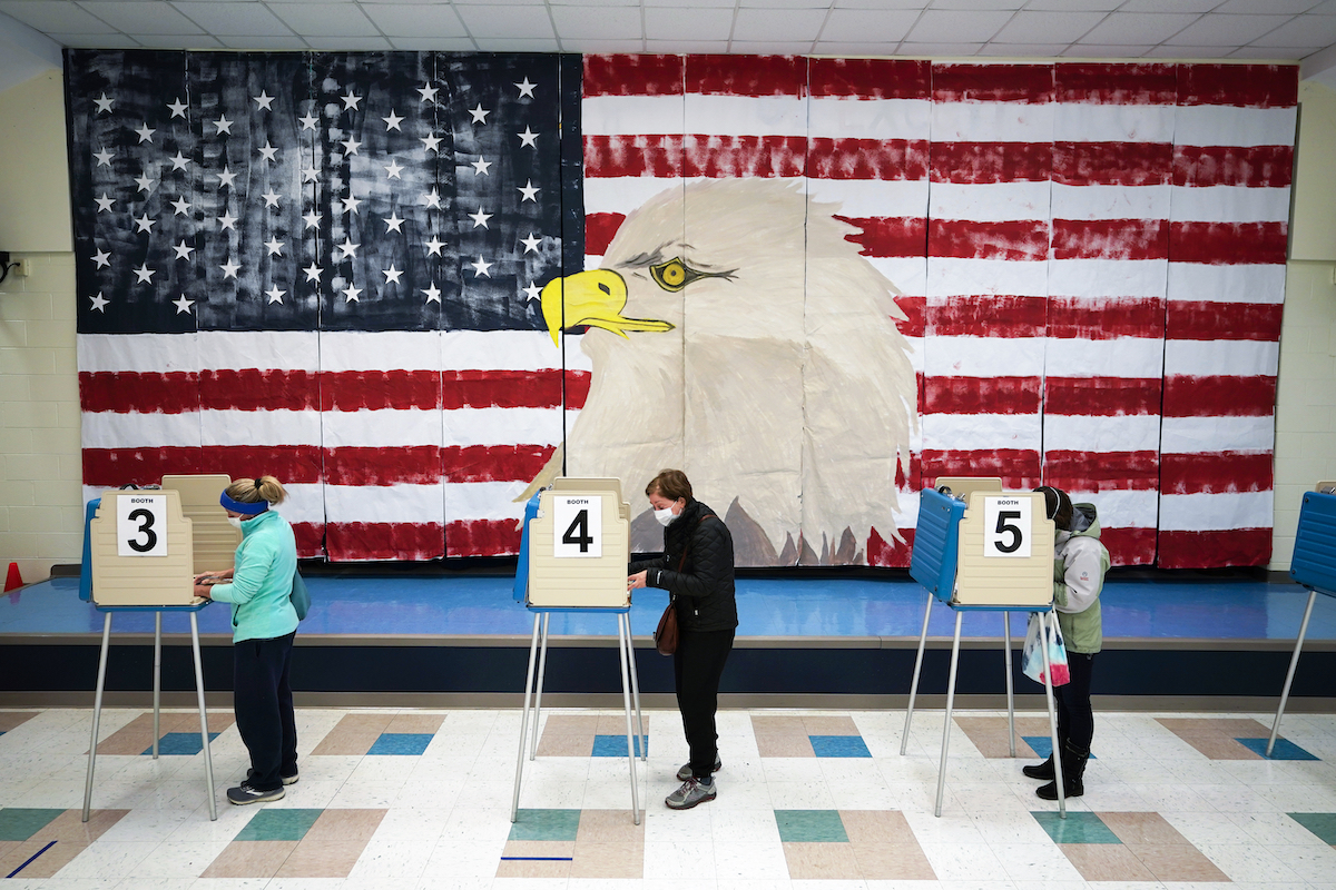 Three voters in front of flag mural in Virginia 11-3-20