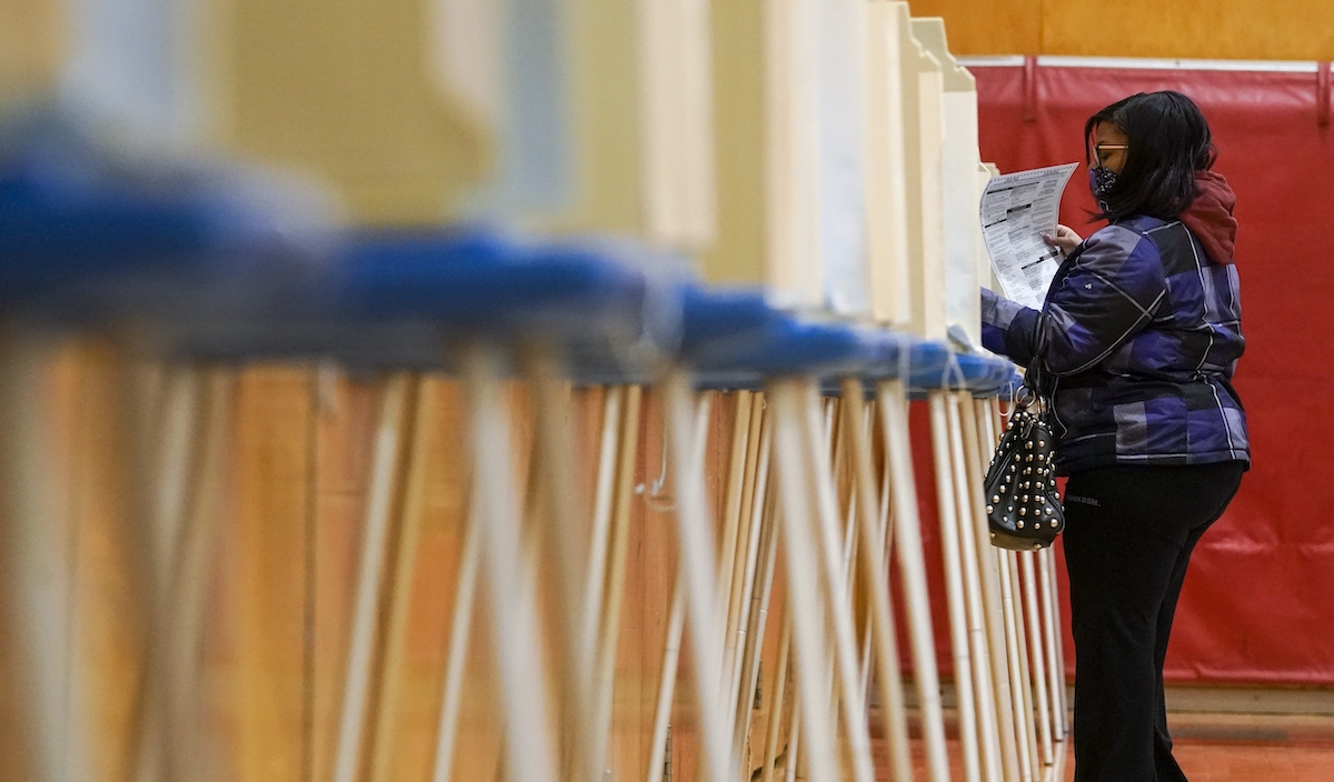 Milwaukee voter with row of voting booths 11-3-20