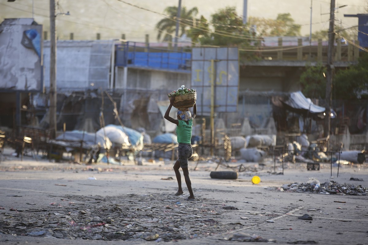 Woman walks across street in Haiti amid unrest, 2-29-2024