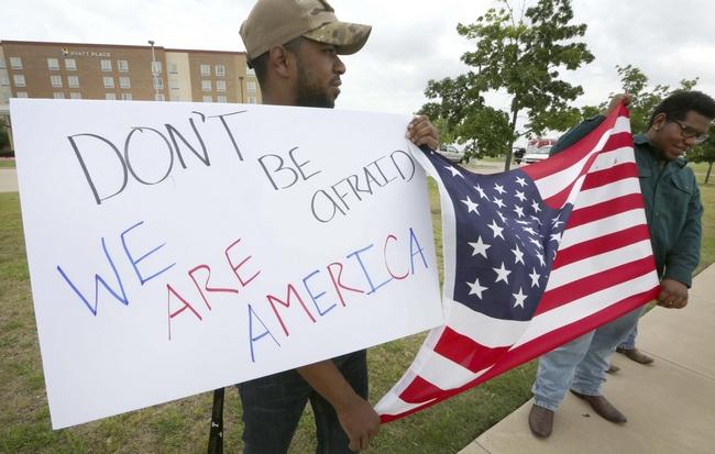 Two men hold poster in Garland