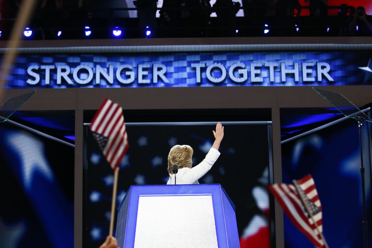 Hillary Clinton waves behind a sign that reads "stronger together" 4
