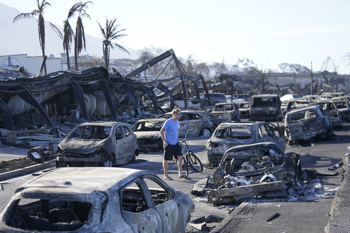 Man walks through wildfire wreckage in Lahaina, Hawaii, 8-11-2023