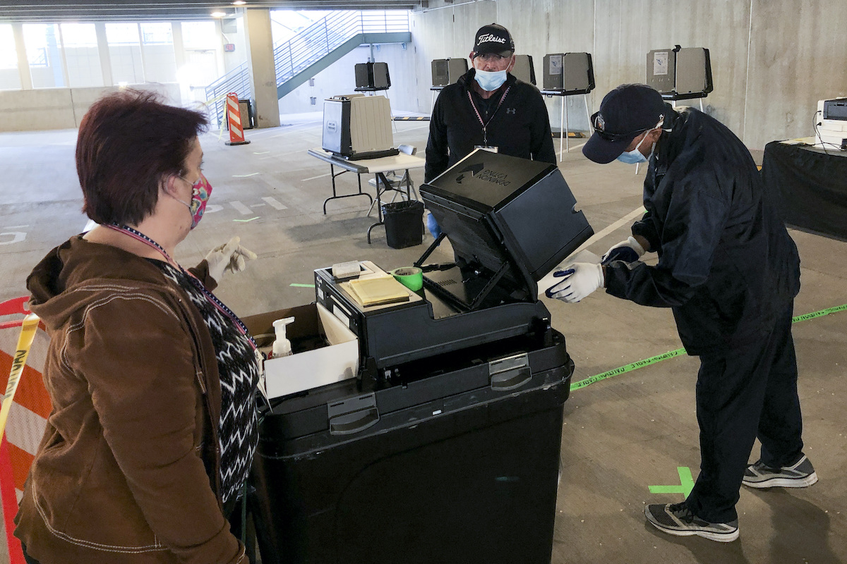 New Mexico voter feeds ballot into tabulator 5-5-20