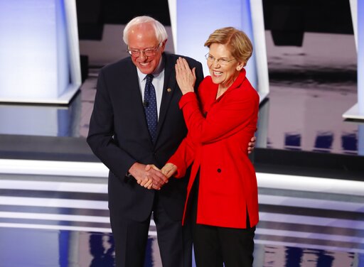 Sanders, Warren shaking hands, hand on chest