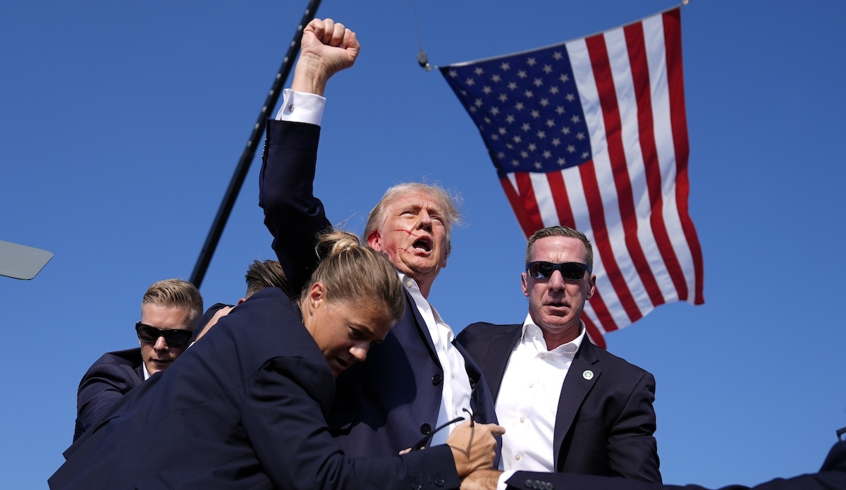 Trump assassination fist raised, flag above - 08-09-2024