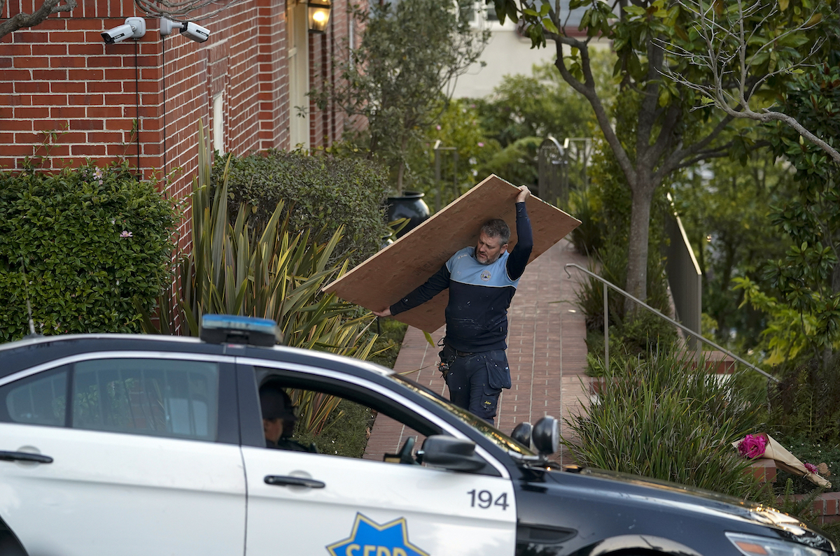 Worker carries plywood from the Pelosi home, Oct. 28, 2022