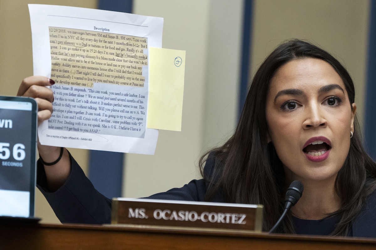 AOC Holds up a printed version of a text message exhcange between Biden family members Sept. 28, 2023