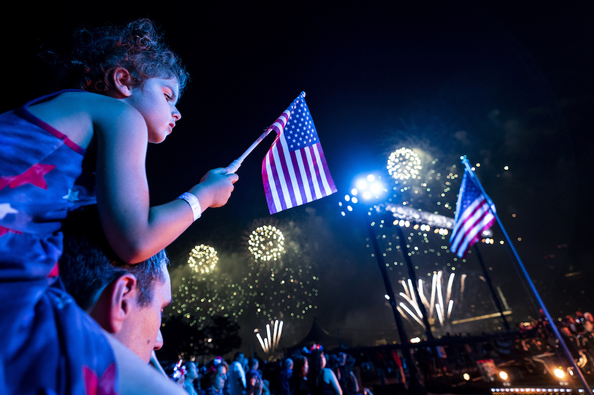 Fourth of july in NYC 2021: Kid on his dad's shoulders waving U.S. flag