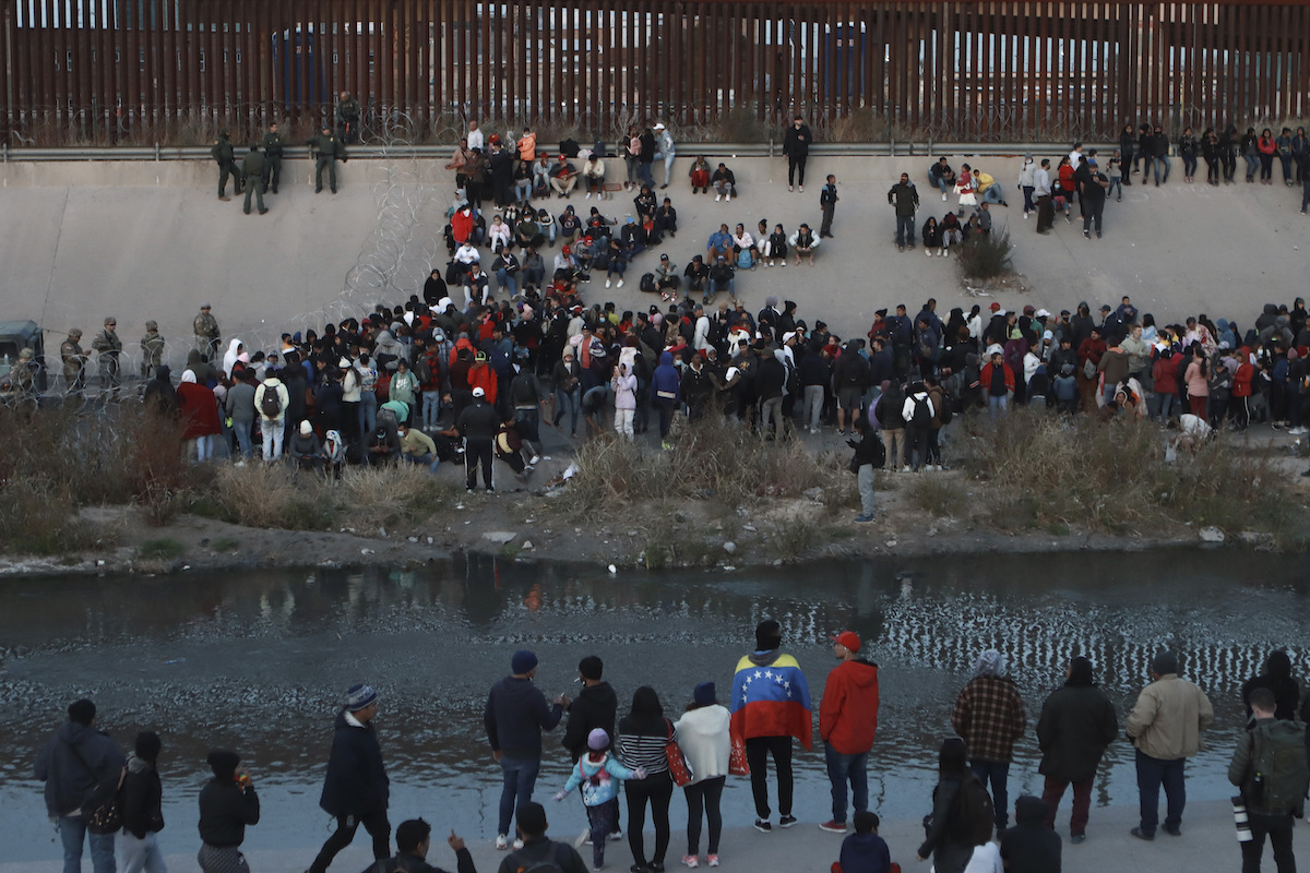 Group of migrants at the border Dec. 2022 on the Mexican side awaiting to get into El Paso