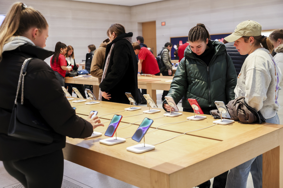 Customers look at phones at Apple Store