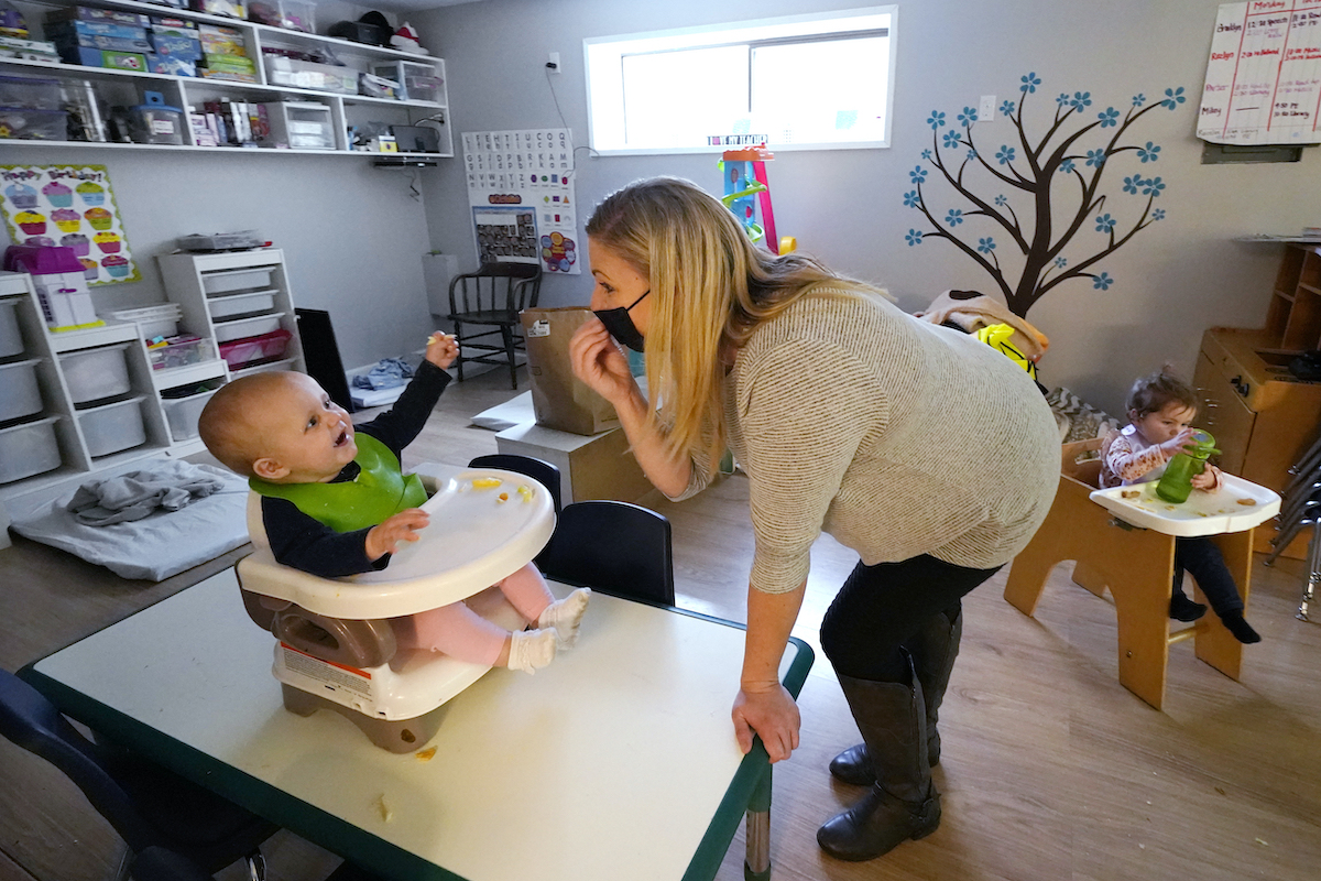 baby interacts with caregiver at daycare