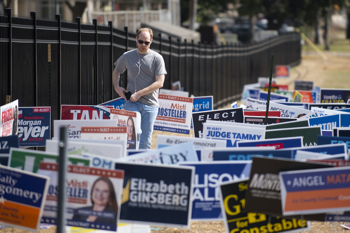 Voter in field of signs in Dallas Texas 3-1-2022 primary election