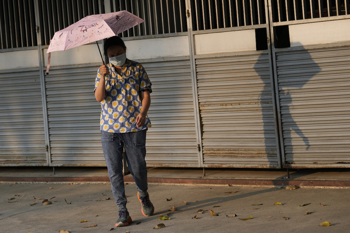 Thailand woman holds umbrella in heat wave