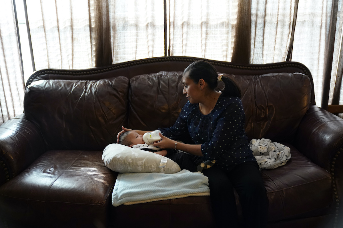 Woman feeds baby a bottle
