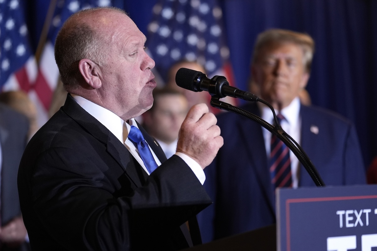 Tom Homan speaking, Trump in background 01-23-24