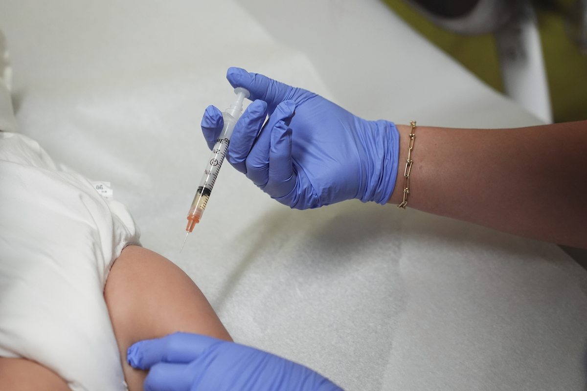 Nurse injects babies leg with MMR vaccine
