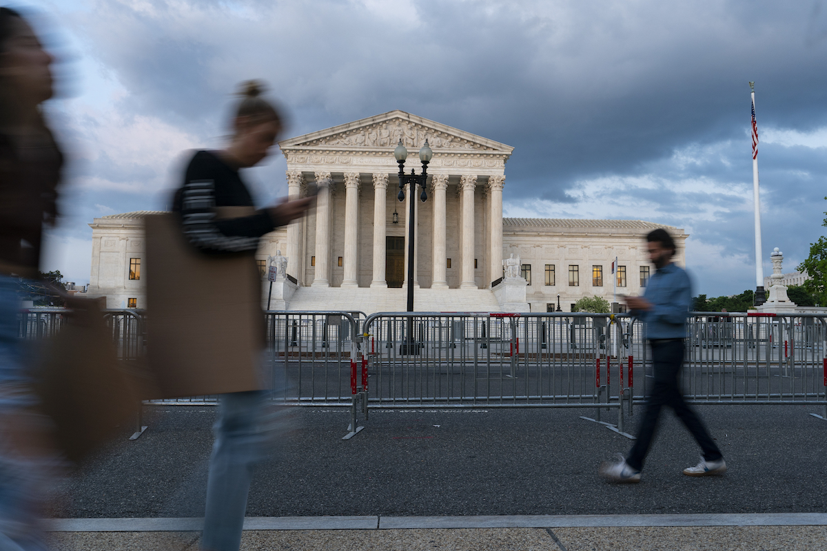 People walk in front of Supreme Court May 4