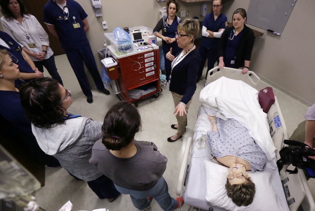 Instructor Betsy Cambridge teaches with mannequin at nursing school