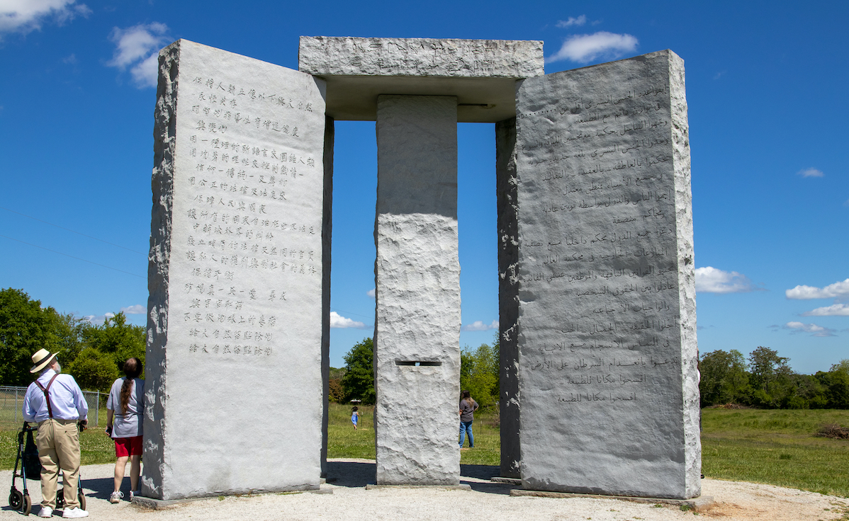 Tourists observe Georgia Guidestones in 2021