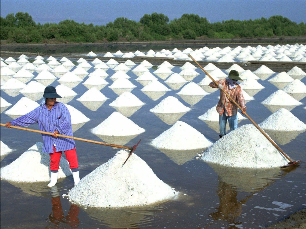 Sea salt farmers work in Bangkok April 27, 1997
