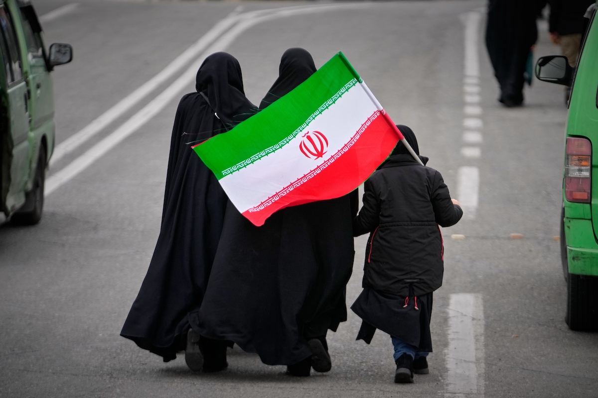 Women walk with Iran flag in Tehran March 20, 2026