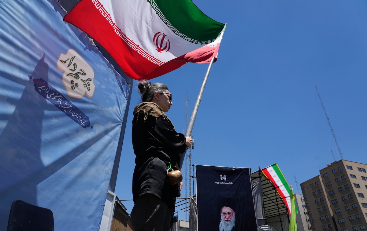 Woman waves Iranian flag, Tehran, Iran, 06-15-2026